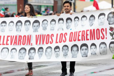 Chicago, Illinois, ABD - 8 Eylül 2019: 26. Cadde Meksika Bağımsızlık Yürüyüşü, erkek ve kadın Meksika 'da kayıp öğrencilerin resimlerinin olduğu bir pankart tutuyorlar.