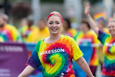 Cincinnati, Ohio, ABD - 22 Haziran 2019 Cincinnati Onur Yürüyüşü, McKesson 'ın reklamını yapan gömlek giyen kadın kameraya gülümsüyor.