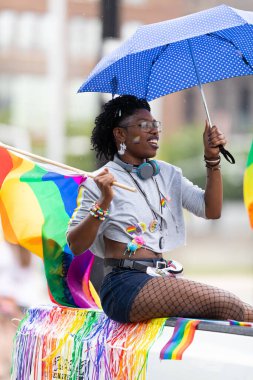 Cincinnati, Ohio, ABD - 22 Haziran 2019: Cincinnati Onur Yürüyüşü, geçit töreninde gökkuşağı bayrağını sallayan bir kadın