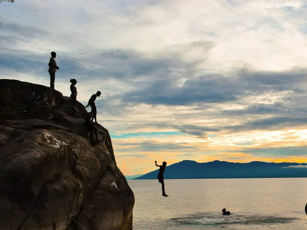 Altın bir günbatımına karşı uçurum dalışı, Kande Sahili, Malavi Gölü