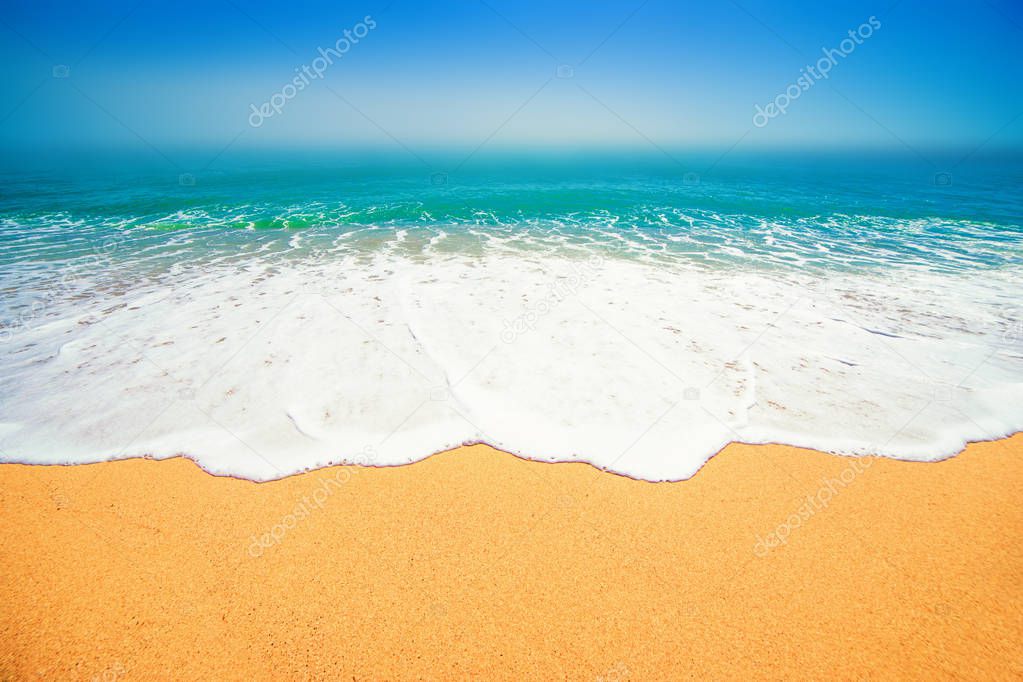 soft wave of blue ocean on sandy beach with blue sky on background, summer travel concept  