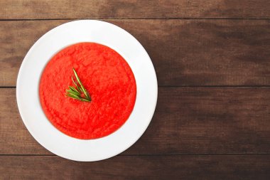 Rustik ahşap masa üzerinde beyaz kase domates çorbası. Üstten görünüm. Kopya alanı. 