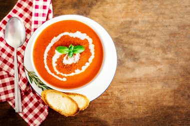 Kruton ve rustik ahşap zemin üzerine taze otlar ile domates çorbası. Krem Gazpacho çorbası. Üstten görünüm. Kopya alanı