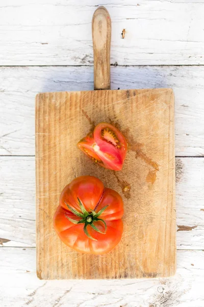 古い木製のテーブルにまな板の上の完熟トマト — ストック写真