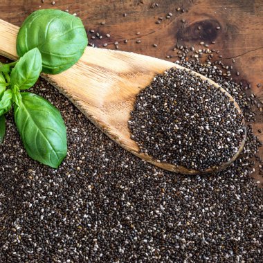 Tahta kaşık ve ahşap arka plan fesleğen yaprağı Chia tohum. Süper yiyecek. Sağlıklı beslenme kavramı. Kopya alanı