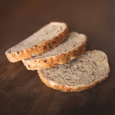 Dilim kepekli ekmek karanlık ructic ahşap arka plan üzerinde 