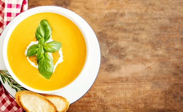 rustik ahşap zemin üzerine croutons kabak ve havuç çorbası.
