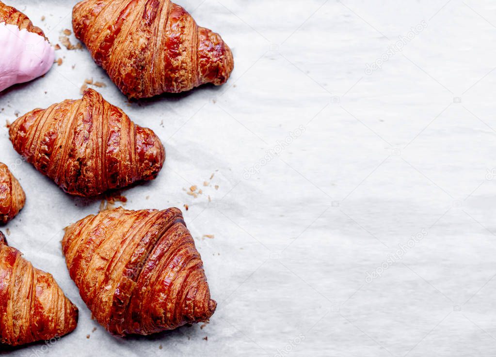 Fresh baked croissants on white baking paper with copy space for text. 