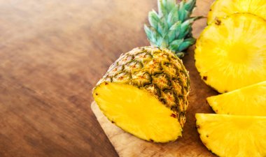 Ahşap doku arka plan üzerinde ananas. Bütün ve dilimlenmiş tropikal ananas kopya alanı ile ahşap kesme tahtası üzerinde. Top vie