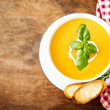 Rustik ahşap zemin üzerine croutons kabak ve havuç çorbası. Sonbahar krem çorba üstten görünüm. Kopya alanı