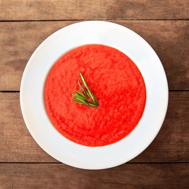 Rustik ahşap masa üzerinde beyaz kase domates çorbası