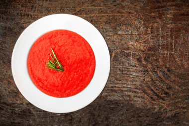 Rustik ahşap masa üzerinde beyaz kase domates çorbası