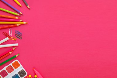 Geri okul kavramı için pembe arka plan üzerinde okul ve ofis malzemeleri