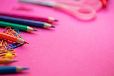 Geri okul kavramı için pembe arka plan üzerinde okul ve ofis malzemeleri