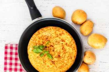 İspanyol patates omlet tortilla de patatas bir rustik ahşap masa, boşaltmak denir. Üstten görünüm
