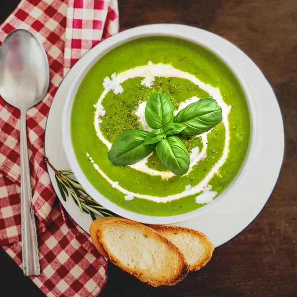 Bowl of Broccoli and fresh green peas cream soup with coconut cream on dark wooden table. Copy space. Top view — Stock Image Bowl Broccoli Fresh Green Peas Cream Soup Coconut Cream Dark Royalty Free Stock Images