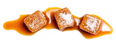 Salted caramel pieces and sea salt isolated on white background. Golden Butterscotch toffee caramels. Toffees, macro clipart