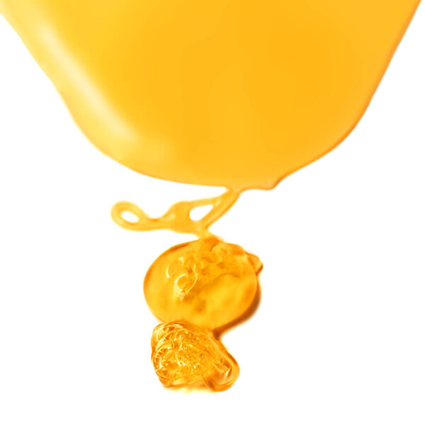 Honey drop isolated on white background. Dripping sweet honey spot, closeup