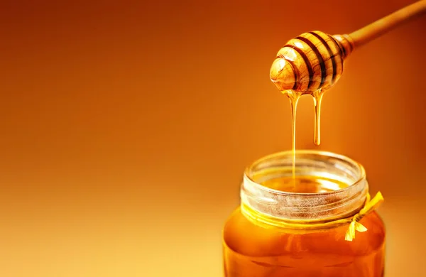 蜂蜜の素朴な木製のテーブル背景に蜂蜜ディッパーの瓶で コピー スペース — ストック写真