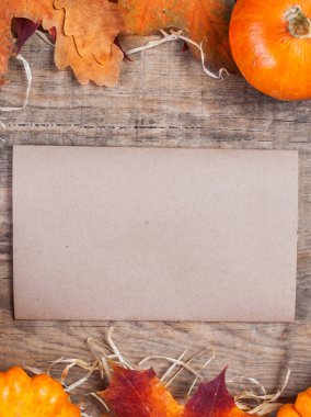 Şükran günü kartı Turuncu kabak ve renkli metin için boş etiket kağıt ahşap zemin üzerine bırakır