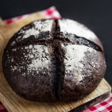 Taze somun kesme tahtası üzerinde karanlık ekmek