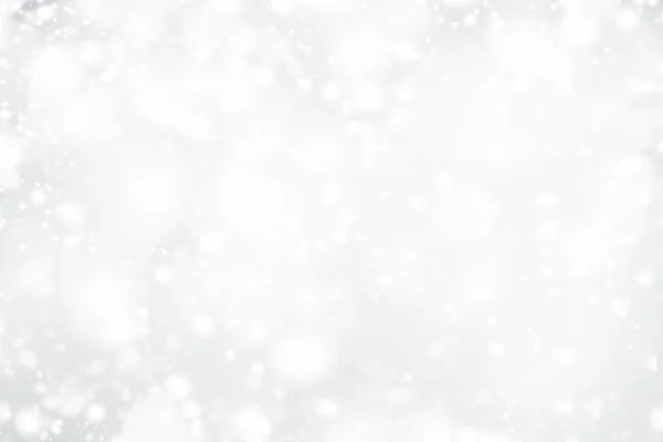 Kar tanesi ve bokeh yıldız pırıltılı gümüş ile beyaz Noel soyut bokeh arka plan. Işık şenlikli Glowing bulanık