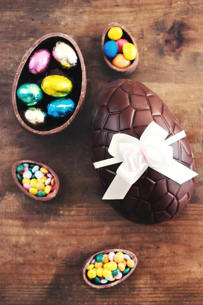 Čokoládová Velikonoční Vejce Dřevěné Pozadí Stuhou Luk Bonbóny Veselé Velikonoce — Stock fotografie