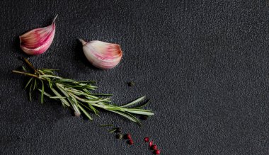 Sarımsak ve biberiye siyah arka plan üzerinde üstten görünüm izole. Kopya alanı ile karanlık gemide çeşitli otlar