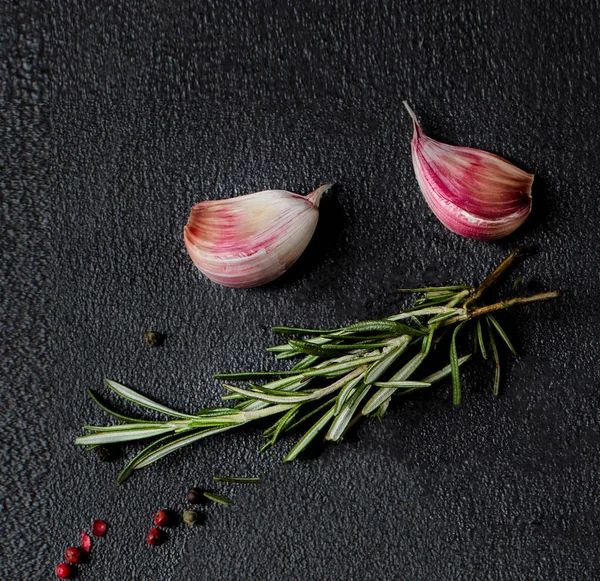 Sarımsak, biberiye otlar ve biber siyah beton zemin, üstten görünüm. Gıda katkı maddeleri