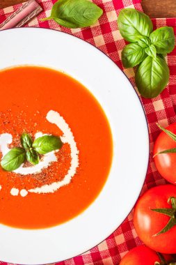 Domates çorbası kompozisyon taze domates, fesleğen yaprağı ve sarımsak bir ahşap masa üzerinde yukarıdan görüntüleyin. Sonbahar yemek