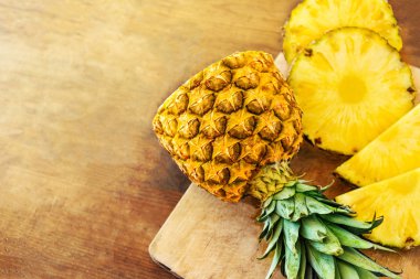 Ahşap doku arka plan üzerinde ananas. Bütün ve dilimlenmiş tropikal 