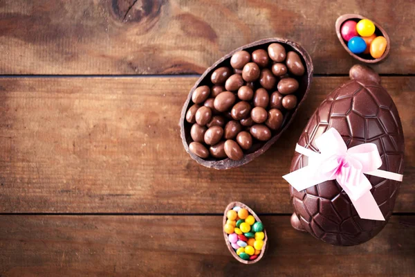 Čokoládová velikonoční vejce na dřevěné pozadí s stuhou luk a c — Stock fotografie