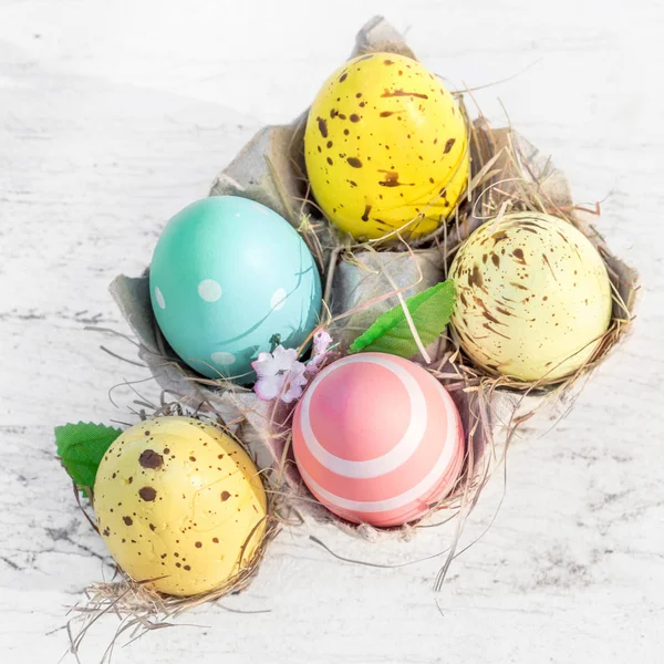 Húsvéti tojás tojás rajzfilm mezőben fehér rusztikus, fából készült háttér — Stock Fotó