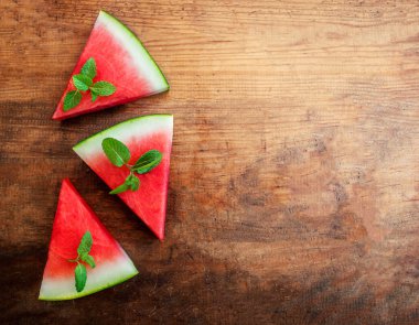 Karpuz dilimi rustik ahşap zemin üzerine nane ile. Boşaltmak.