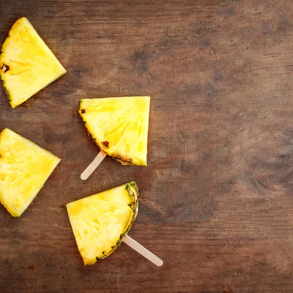 Ananas segment ijslollys op een bruin rustiek houten achtergrond. FL — Stockfoto