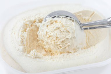 Arka plan olarak kapsayıcısında bir kepçe ile vanilyalı dondurma. Makro. Dondurma, en iyi görünümü scooped.