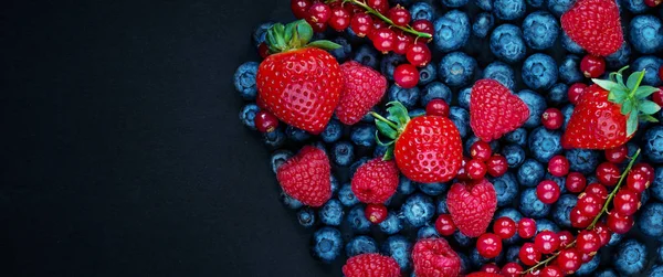 Berry mix isolated on black concrete background. Copy space. Var