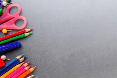 Okula geri dön. Sınıflar ve dersler için gri arka plan üzerinde okul malzemeleri. Düz yatıyordu. Top vie