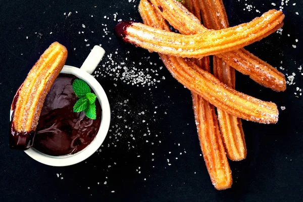 Churros con azúcar y salsa de chocolate sobre fondo negro. Ch — Foto de Stock