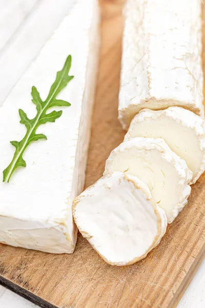 Tavola di legno con vari formaggi su sfondo bianco. Palla di formaggio — Foto Stock