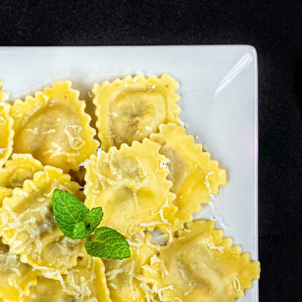 Fresh raviolli on a white plate  over  dark background, top view — Stock Photo, Image