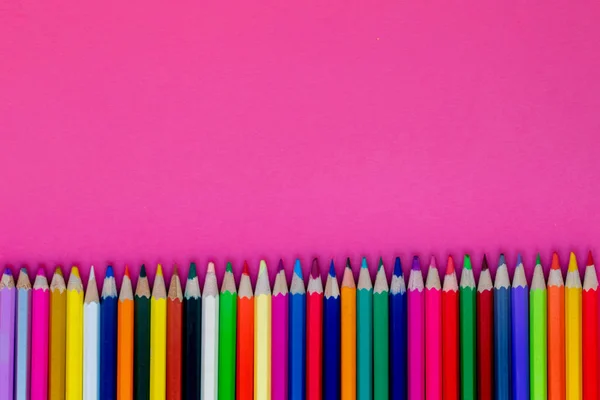 Pensilios de colores sin costura en una fila sobre fondo rosa. Cerrar u —  Fotos de Stock