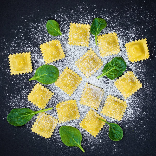 Verse ravioli pasta met spinazie, bloem en kruiden op donkere backgr — Stockfoto