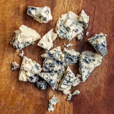 Koyu ahşap arka planda Gorgonzola peyniri. Mavi mol parçaları