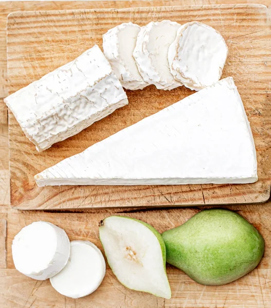 Tabla de quesos con diferentes quesos, peras y uvas en blanco w —  Fotos de Stock