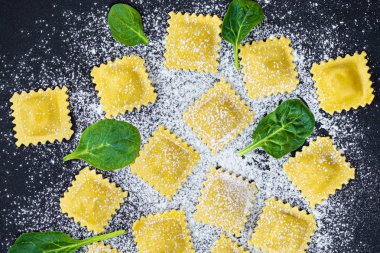 Ispanak, un ve koyu backgr üzerinde otlar ile taze ravioli makarna