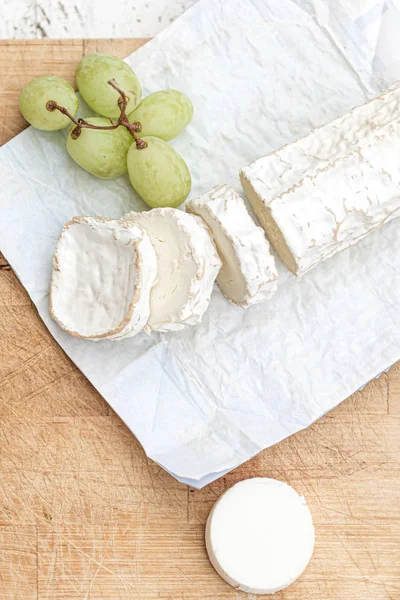 Bandeja de queso con diferentes quesos y uvas en madera blanca —  Fotos de Stock
