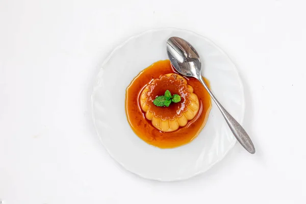 Flan nebo karamelová pudink s mátou na bílé desce nad w — Stock fotografie