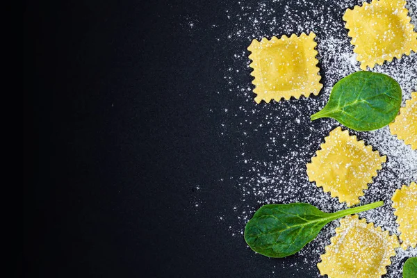 Fresh ravioli pasta with Spinach, flour and herbs on dark backgr — Stock Photo, Image