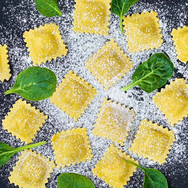 Fresh ravioli pasta with Spinach, flour and herbs on dark backgr — Stock Photo, Image